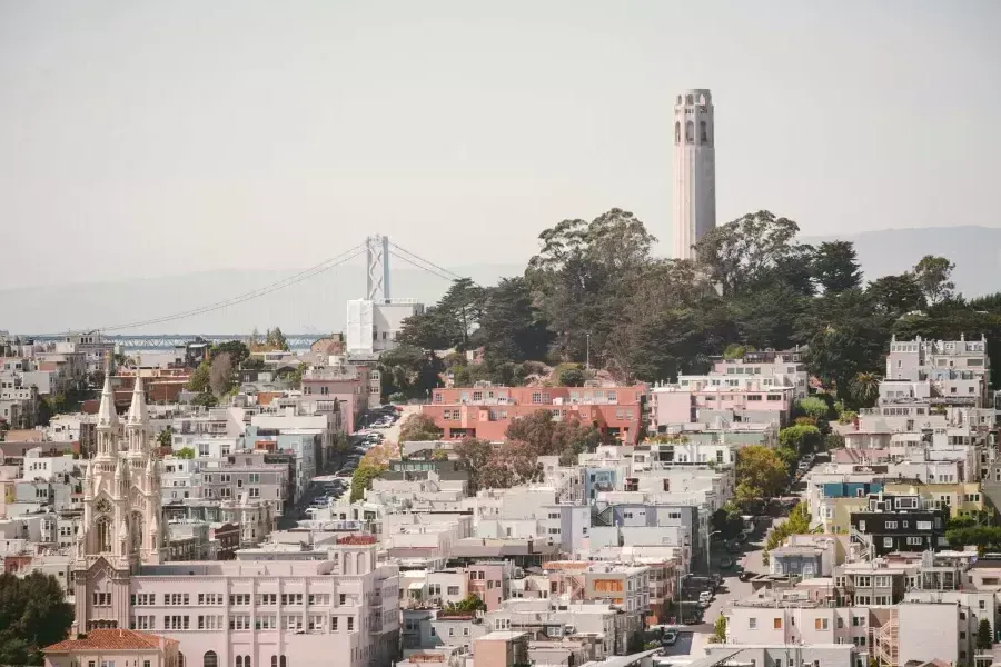 贝博体彩app科伊特塔(Coit塔)的背景是海湾大桥(Bay Bridge)和一座满是房屋的小山.